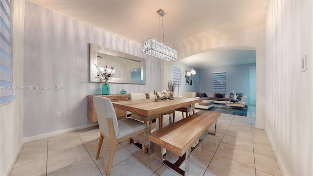 tiled dining area featuring a chandelier