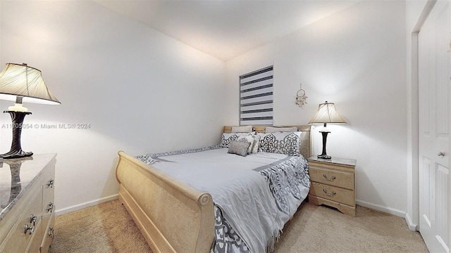 bedroom with a closet, light colored carpet, and lofted ceiling