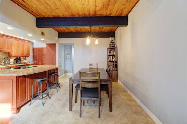 tiled dining area featuring beamed ceiling and wood ceiling