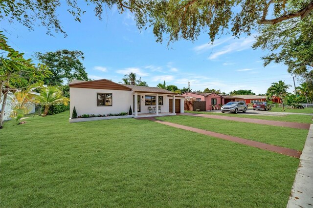 ranch-style house featuring a front lawn and covered porch