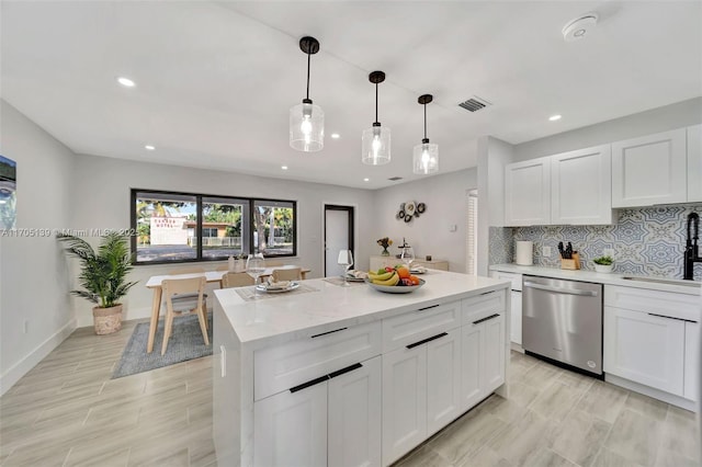 kitchen with hanging light fixtures, a center island, stainless steel dishwasher, and white cabinets