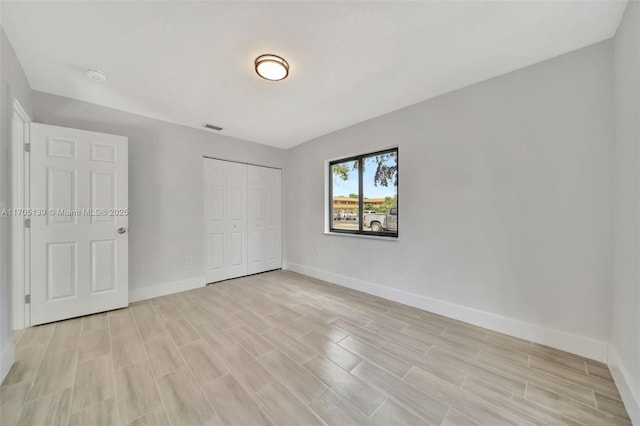 unfurnished bedroom featuring light hardwood / wood-style floors and a closet