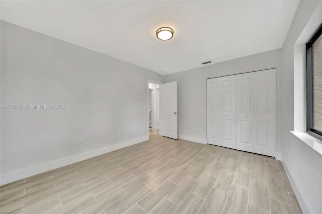 unfurnished bedroom featuring a closet and light wood-type flooring