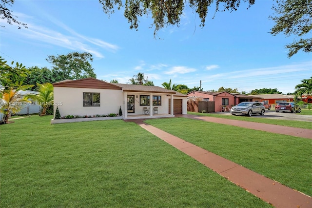 single story home with a garage and a front lawn