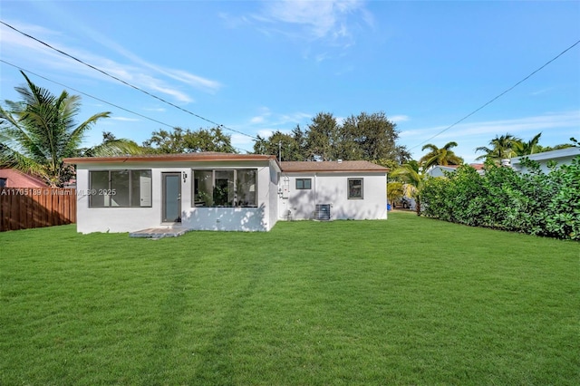 back of house featuring a lawn and central air condition unit