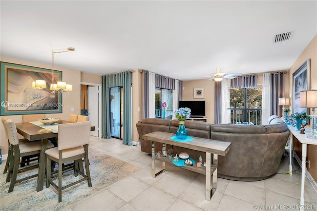 living room with ceiling fan with notable chandelier and light tile patterned floors