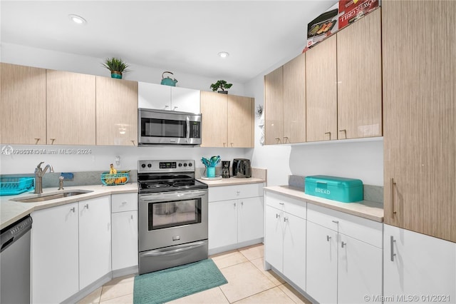 kitchen featuring light brown cabinetry, light tile patterned floors, sink, and appliances with stainless steel finishes