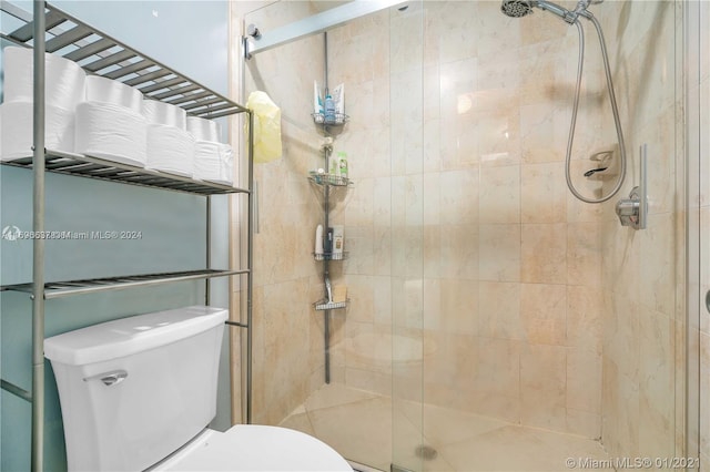 bathroom with toilet and a shower with shower door