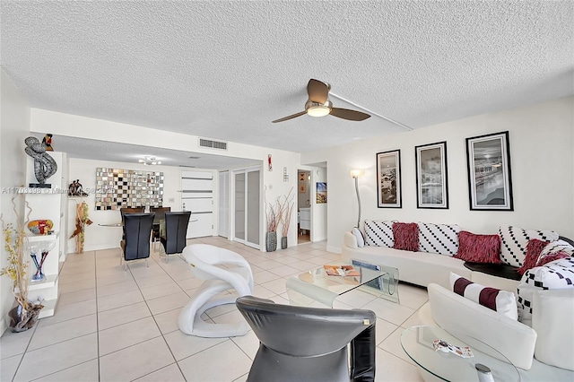 living room featuring tile patterned flooring, a textured ceiling, and ceiling fan