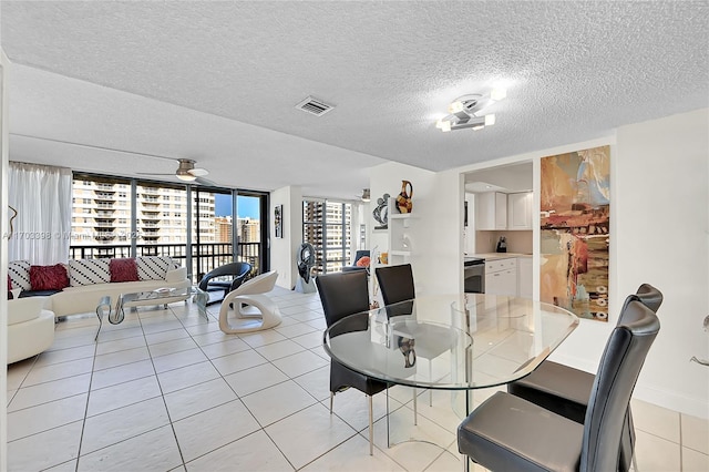 tiled dining area featuring ceiling fan and a textured ceiling