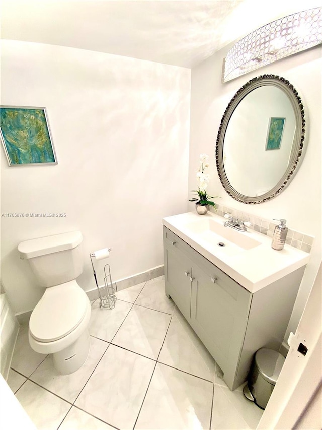 bathroom featuring tile patterned flooring, toilet, vanity, and baseboards