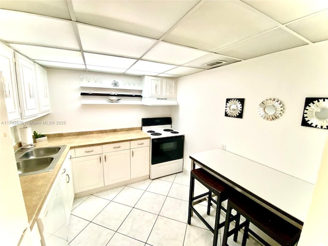 kitchen featuring under cabinet range hood, electric stove, white cabinets, a paneled ceiling, and a sink