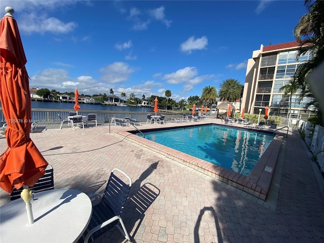 view of pool with a water view and a patio