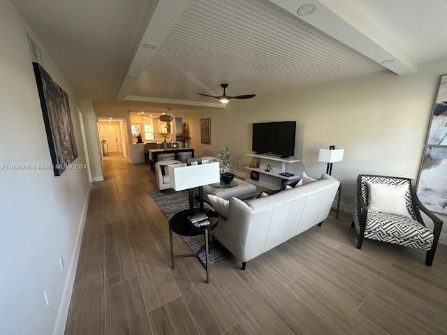 living room featuring beam ceiling, hardwood / wood-style flooring, and ceiling fan