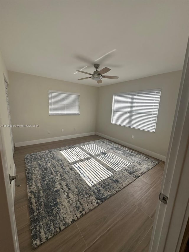 spare room featuring ceiling fan and dark hardwood / wood-style flooring