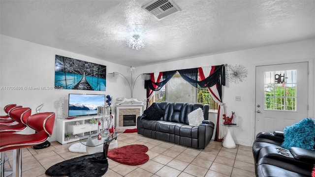 tiled living room featuring a fireplace and a textured ceiling