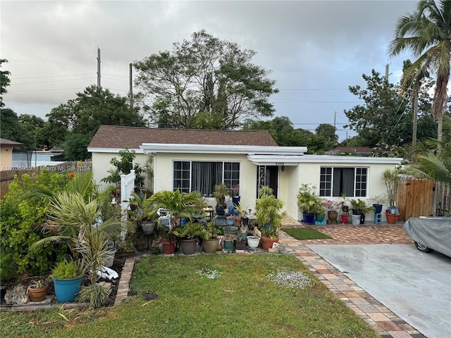 ranch-style home with a patio and a front lawn