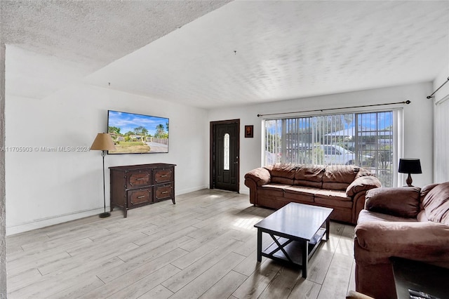 living room with a textured ceiling and light wood-type flooring