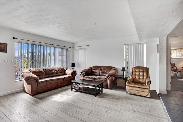 living room with light hardwood / wood-style floors and a textured ceiling