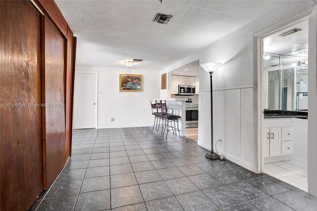 hall with a textured ceiling