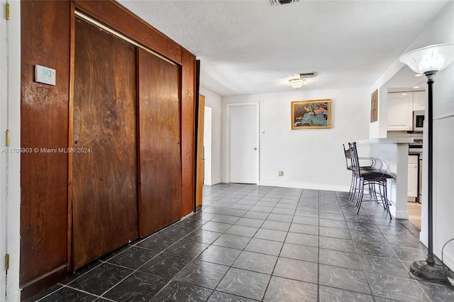 hall with a textured ceiling