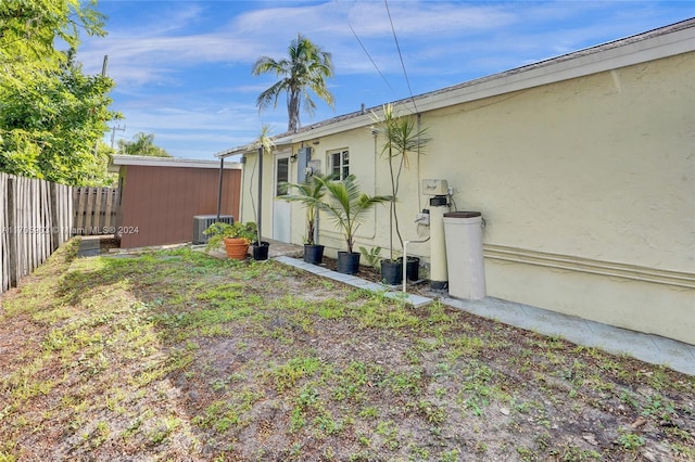 view of yard featuring a storage unit and central air condition unit