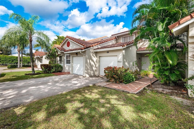 mediterranean / spanish home with a front lawn and a garage