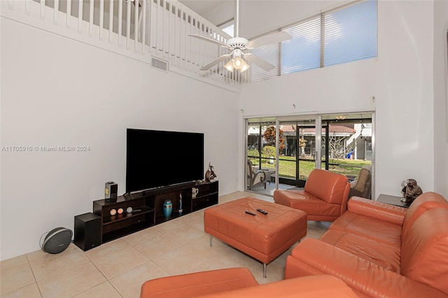 living room featuring light tile patterned floors, a towering ceiling, and ceiling fan