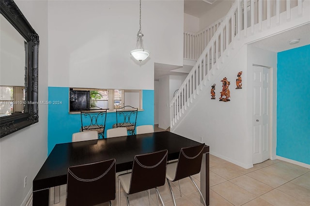 dining room featuring light tile patterned flooring, a towering ceiling, and a wealth of natural light