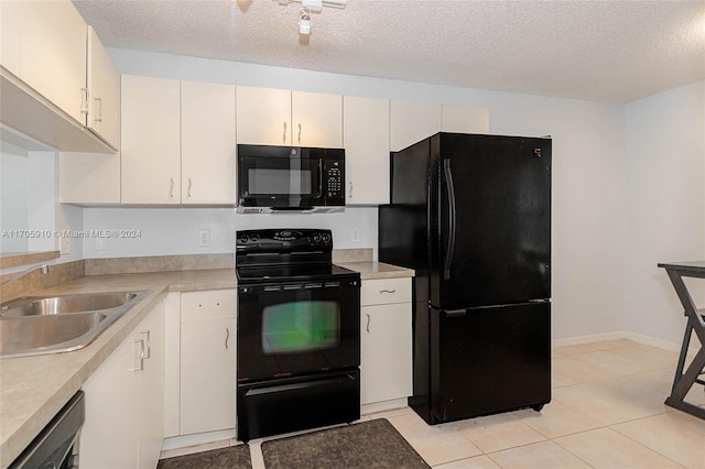 kitchen with sink, light tile patterned floors, a textured ceiling, and black appliances