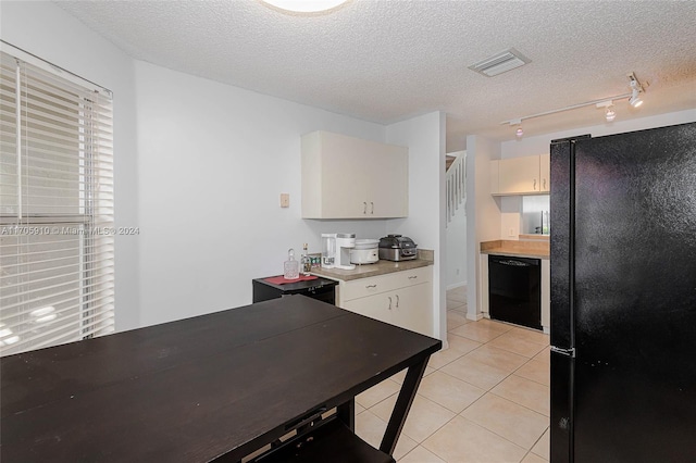 kitchen with light tile patterned floors, a textured ceiling, and black appliances