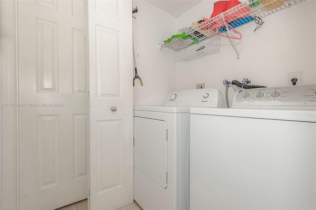 laundry room featuring washer and dryer and light tile patterned floors