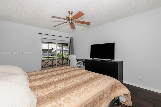 bedroom featuring dark hardwood / wood-style floors, ceiling fan, and a textured ceiling