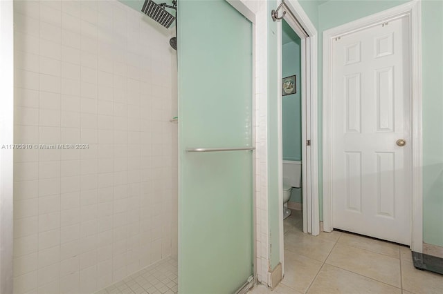 bathroom featuring tiled shower, tile patterned floors, and toilet