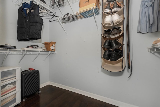 walk in closet with dark hardwood / wood-style flooring