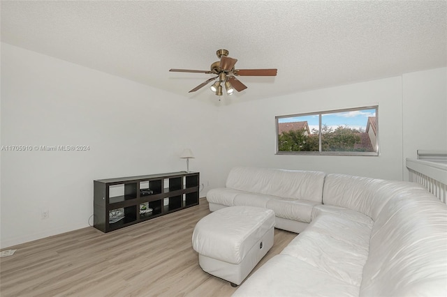 living room featuring a textured ceiling, light hardwood / wood-style floors, and ceiling fan