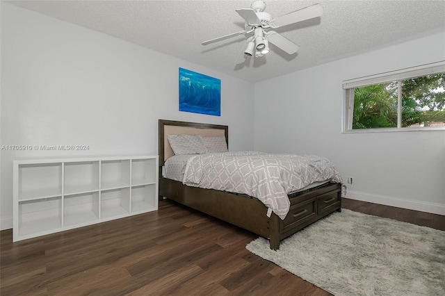 bedroom with a textured ceiling, ceiling fan, and dark wood-type flooring