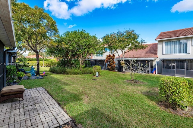 view of yard with a sunroom and a patio area