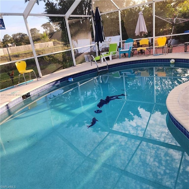 view of swimming pool featuring a lanai and a patio