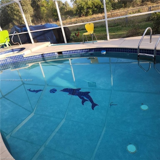 view of pool featuring a jacuzzi, a patio area, and a lanai