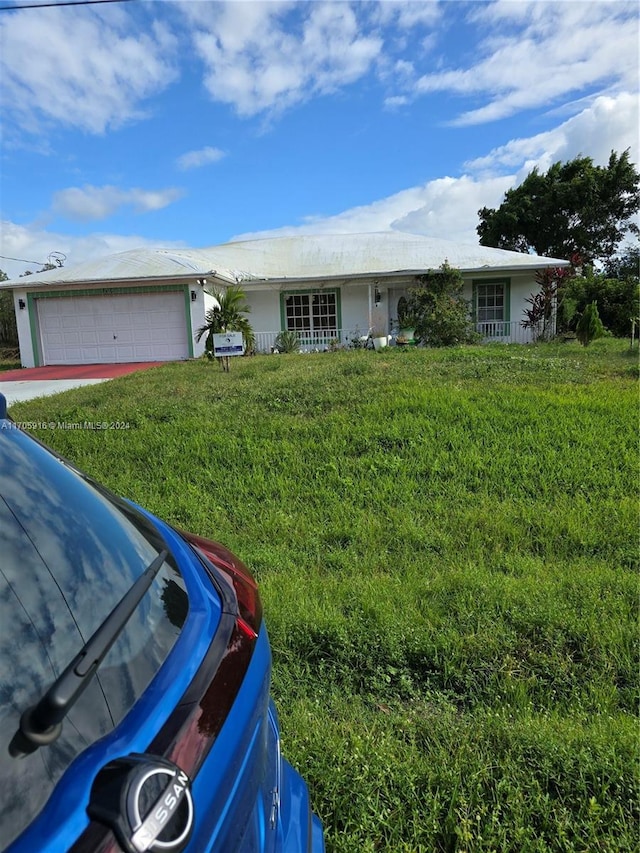 ranch-style home featuring a garage and a front lawn