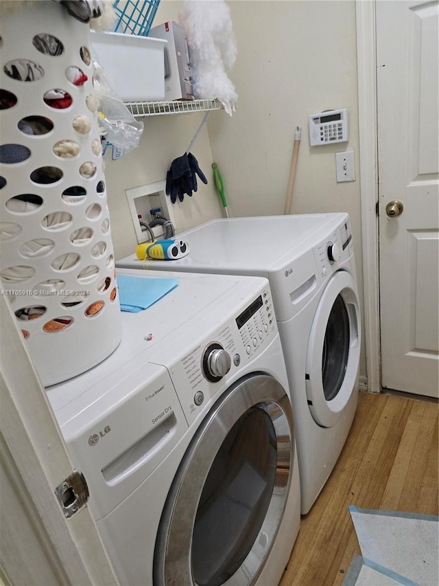 washroom featuring washing machine and clothes dryer and light wood-type flooring