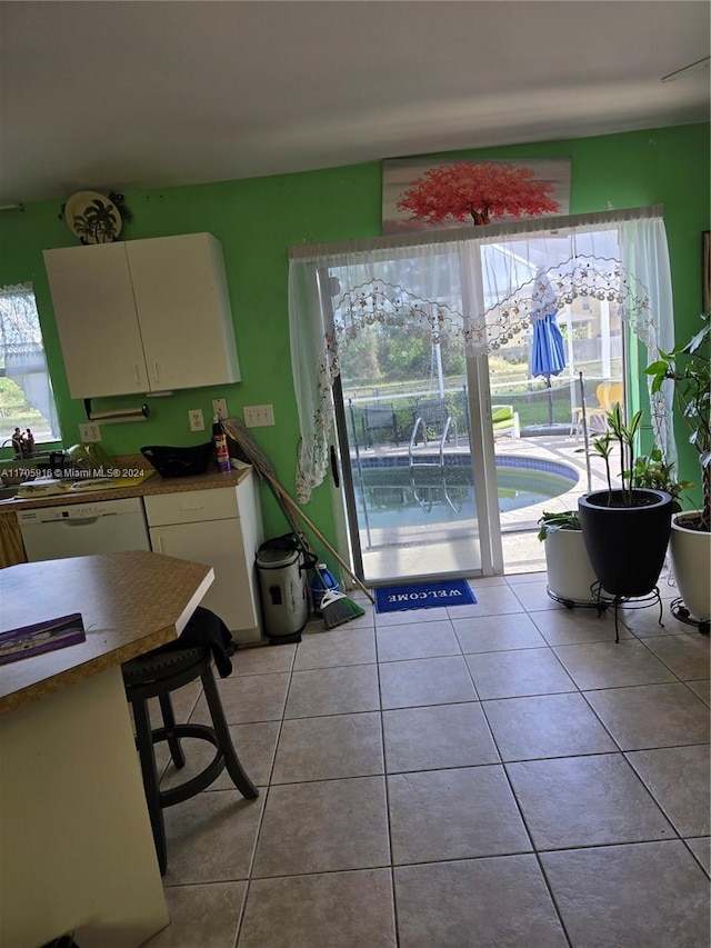 interior space featuring light tile patterned flooring and white dishwasher