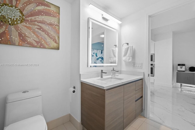 bathroom featuring tile patterned flooring, vanity, and toilet