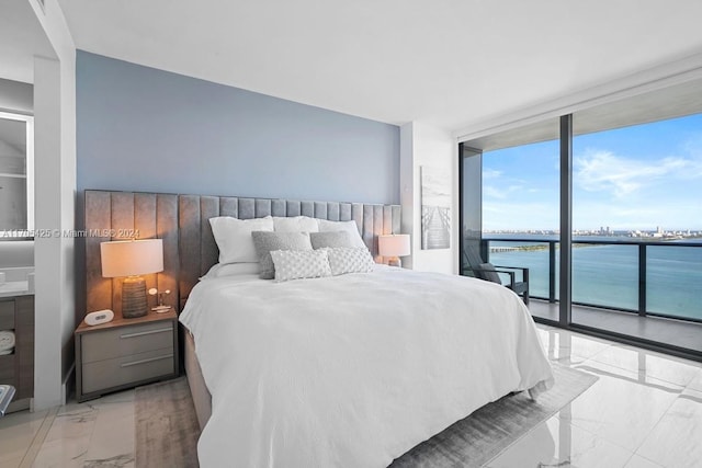 bedroom featuring access to outside, a water view, and expansive windows