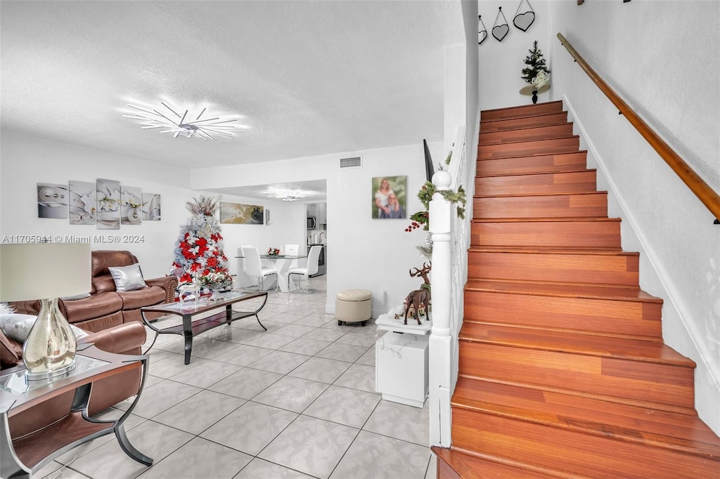 staircase featuring tile patterned floors and a textured ceiling