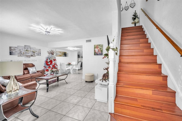 staircase featuring tile patterned floors and a textured ceiling