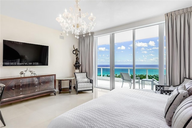 bedroom featuring access to exterior, multiple windows, a water view, and a chandelier