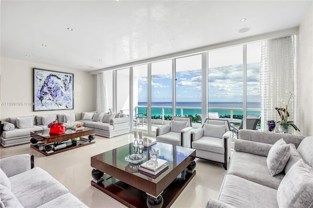 living area featuring a wealth of natural light, recessed lighting, a wall of windows, and a water view