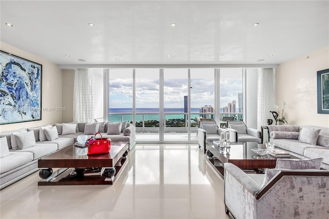 tiled living area featuring a wall of windows, plenty of natural light, recessed lighting, and a water view